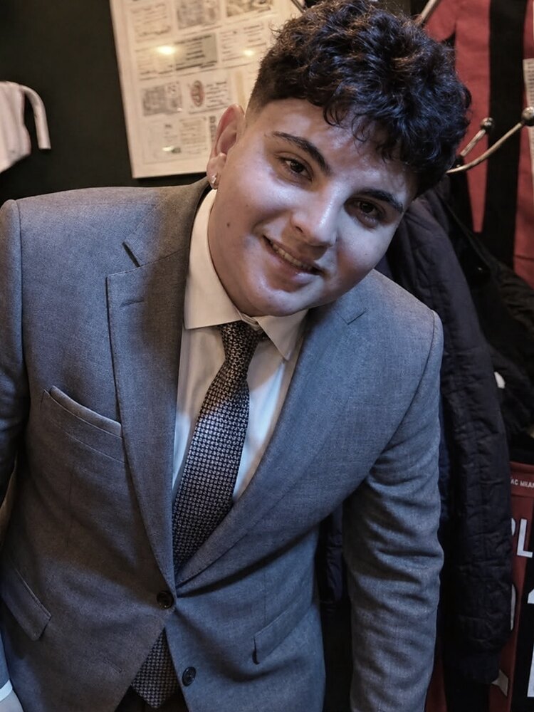 Aaron Alba sonriendo, con traje gris